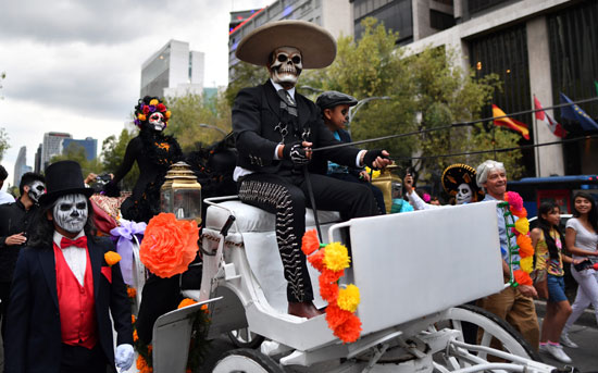  رجل يركب الحنطور خلال الاحتفال بيوم الموتى فى المكسيك
